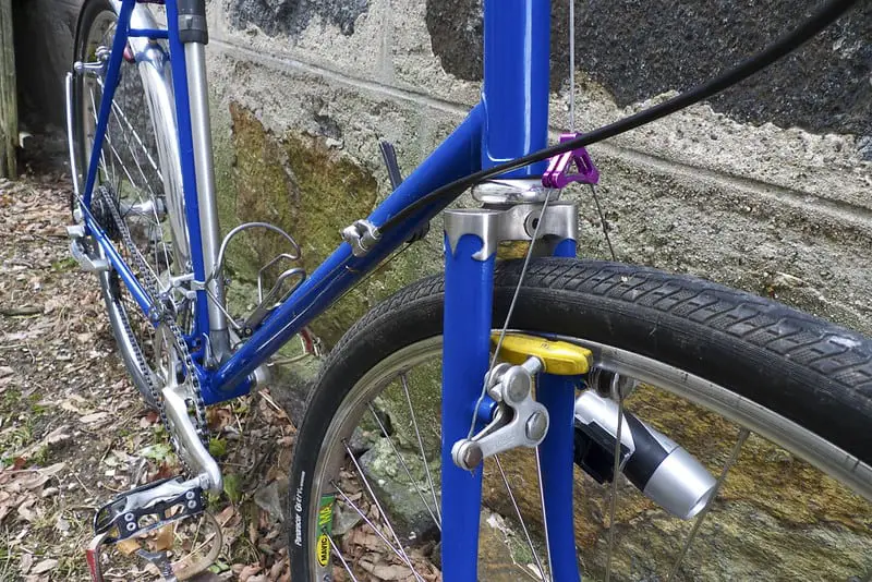 A restored blue bicycle resting on a wall