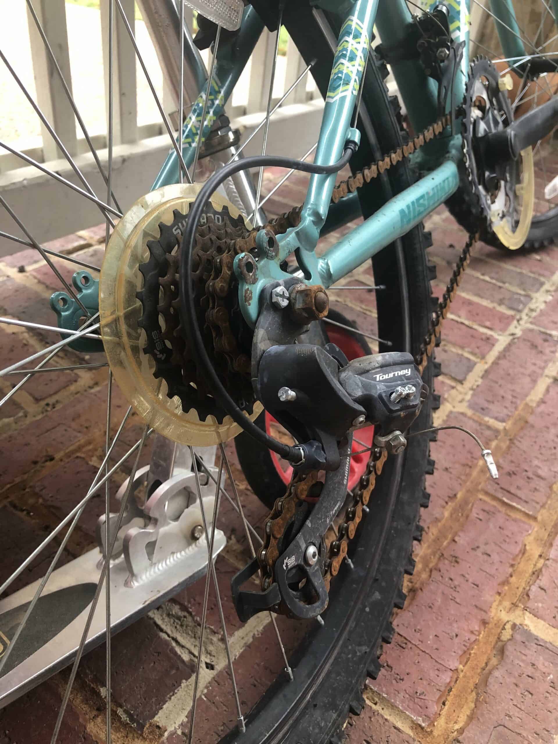 Bike Chain with Cassette and derailleur with a scooter in the background